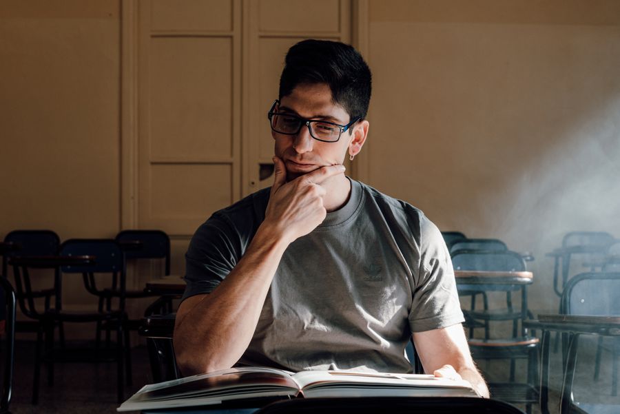 Adolescente pensativo diante de um livro